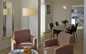 - un salon avec une table et des chaises ainsi qu'une salle à manger dans l'établissement Citadines Kléber Strasbourg, à Strasbourg
