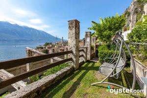 a bench next to a fence with a view of the water at Hotel Castell - Montagnoli Group in Limone sul Garda