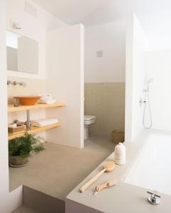 a white bathroom with a sink and a toilet at HoMe Hotel Menorca in Ciutadella