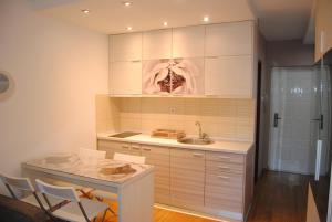 a kitchen with a sink and a table and chairs at Relax Apartment in Vrnjačka Banja +11 photos