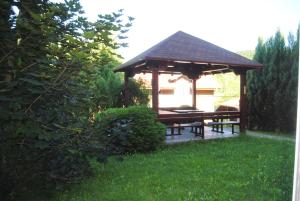 a gazebo with a picnic table in a yard at Relax Apartment in Vrnjačka Banja