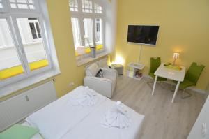 ビンツにあるVilla Sirene - Wohnung 08のベッド、ソファ、テレビが備わる客室です。