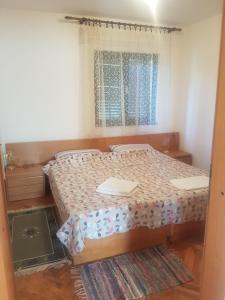 um quarto com uma cama e uma janela em Villa Maja em Omišalj