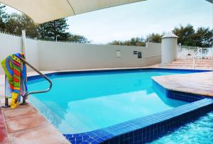 a swimming pool with a raft in the middle at Golden Sands on the Beach - Absolute Beachfront Apartments in Gold Coast
