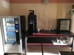 a vending machine next to a table with a refrigerator at Sweet Home in Treviso