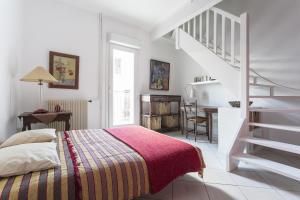 biała sypialnia z łóżkiem i schodami w obiekcie Apartment Maison Fanjeaud w mieście Pézenas