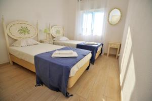 una camera da letto con due letti e uno specchio di Sunhouse a Luz