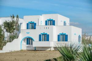 a white building with blue windows on the beach at Magic Summer in Agia Anna Naxos