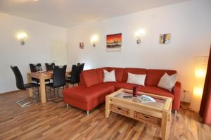 奧茨巴德賓茲的住宿－Villa Strandidyll Wohnung 9，客厅配有红色的沙发和桌子