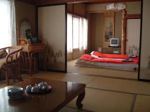 um quarto com uma cama vermelha e um espelho em Onsen Inn 36So em Matsumoto