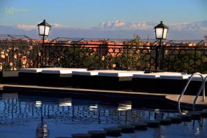 una piscina con tumbonas y vistas a las montañas en Hotel Imperial Plaza & Spa, en Marrakech