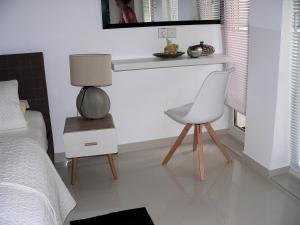sypialnia z łóżkiem, krzesłem i stołem w obiekcie Gästehaus Isabella w mieście Beruwala