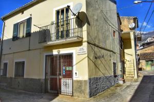 a yellow building with a door and a balcony at Ka Dërrasëza in Frascineto