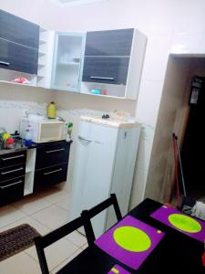 a small kitchen with a table and a microwave at Casa de Campo Serra Negra in Serra Negra