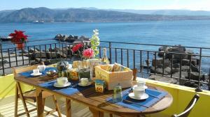 a table on a balcony with a view of the water at Casa Dei Saraceni in SantʼAgata