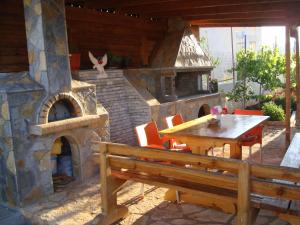 a patio with a wooden table and a stone oven at Ksamil Harmony Studios in Ksamil