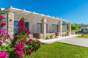 a house with pink flowers in the yard at Kordistos Hotel in Kefalos