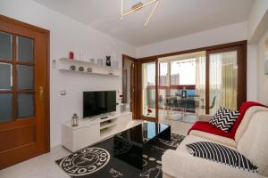 salon z kanapą i telewizorem w obiekcie "Gemelos 15" Vacation w mieście Benidorm