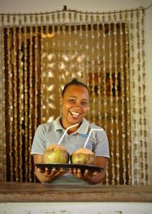 un joven sosteniendo un plato con dos manzanas en Matemwe Lodge, en Matemwe