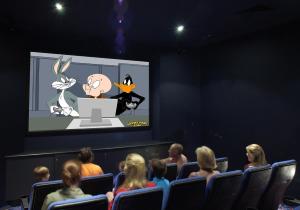 a group of people sitting in a theater watching a cartoon at Turtle Beach Resort in Gold Coast