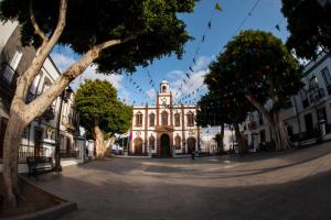 a building with a clock tower in the middle of a street at Casa Lola in Agaete