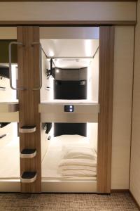 a small closet with a bed in a room at Cabin & Capsule Hotel J-SHIP Osaka Namba in Osaka