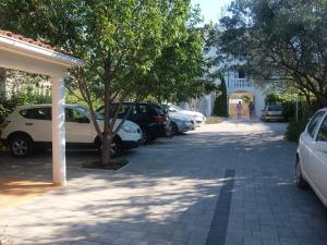 a row of parked cars parked on a sidewalk at Apartments Paloma Blanca in Medulin