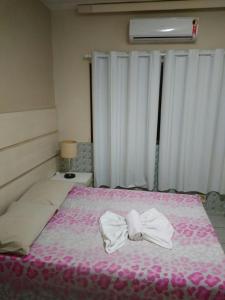 Un dormitorio con una cama con una pajarita. en Pousada Sandra Convenções, en Recife