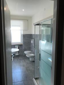 ヴェローナにあるPoloni Apartmentのバスルーム(トイレ2つ、ガラス張りのシャワー付)