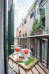 een tafel met twee drankjes en koekjes op een balkon bij San Marco Romantic Dream in Venetië