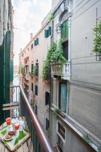 a balcony with a table with wine glasses on it at San Marco Romantic Dream in Venice