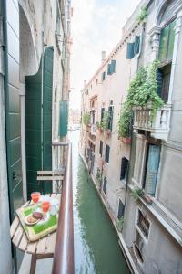 een uitzicht op een gracht met een tafel op een balkon bij San Marco Romantic Dream in Venetië
