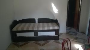 uma pequena cama num canto de um quarto em Flomar em Piriápolis