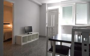 a room with a desk with a television and a bed at Paseo do Mar 2 in Ézaro