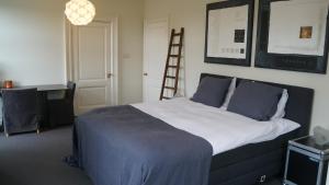 1 dormitorio con 1 cama con escalera en la pared en Room One-Twenty-One en Naarden