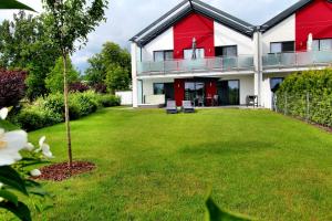 una casa roja y blanca con un patio verde en Villa Grande Fewo Enjoy We 2, en Göhren-Lebbin