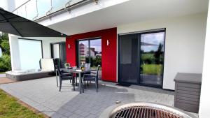 un patio con mesa y sillas en un edificio en Villa Grande Fewo Enjoy We 2, en Göhren-Lebbin