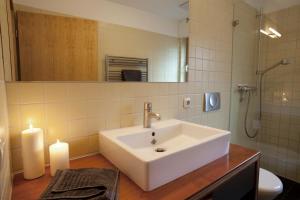 a bathroom with a sink and a mirror and two candles at Eldehaus Plau am See in Plau am See