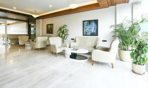 una sala de espera con muebles blancos y macetas en Treebo Tryst Eden Residency, en Gurgaon