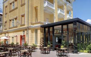an outdoor patio with tables and chairs in front of a building at Hotel Continental ex Gardenija in Opatija