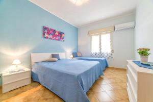 una camera blu con un letto e una finestra di Selinunte's Home a Marinella di Selinunte