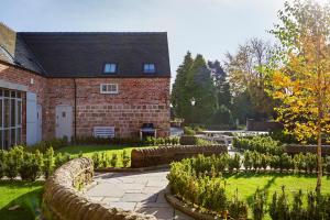 una casa de ladrillo con un jardín delante de ella en 1 Collared Dove Barn en Stoke on Trent