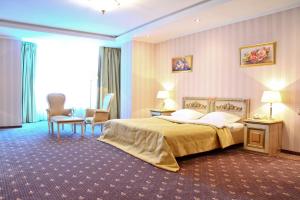 a hotel room with a large bed and chairs at SK Royal Hotel Moscow in Moscow