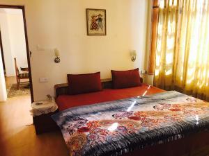 a bedroom with a bed with a red blanket at RidgeView Homestay near Lakkar Bazar in Shimla