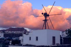 a windmill sitting on top of a white building at Casa Lola in Agaete