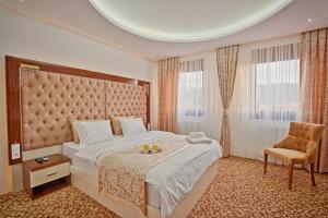 una camera d'albergo con un letto grande e una sedia di New Hotel a Sarajevo