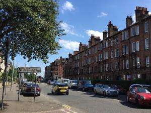 una calle con coches estacionados al costado de la carretera en Scotstoun 1 Bed Flat en Glasgow