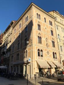 un grand bâtiment avec des tables devant lui dans l'établissement 9 stanze - Boutique Rooms, à Trieste