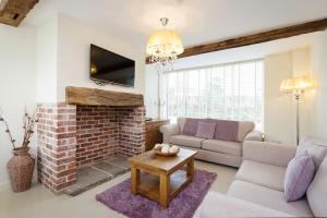 a living room with a couch and a brick fireplace at 1 Luzon Dove Barn in Stoke on Trent