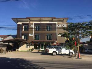 um camião branco estacionado em frente a um edifício em Bansappoori em Lamphun